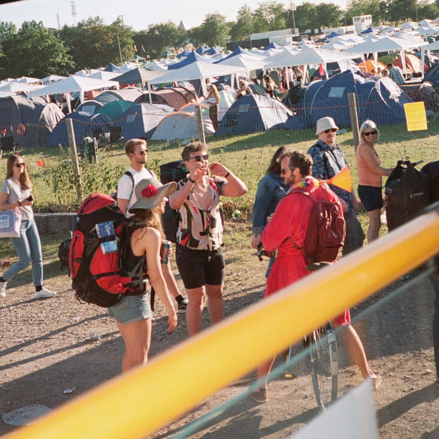 Grupp av människor på festival, med tält i bakgrunden
