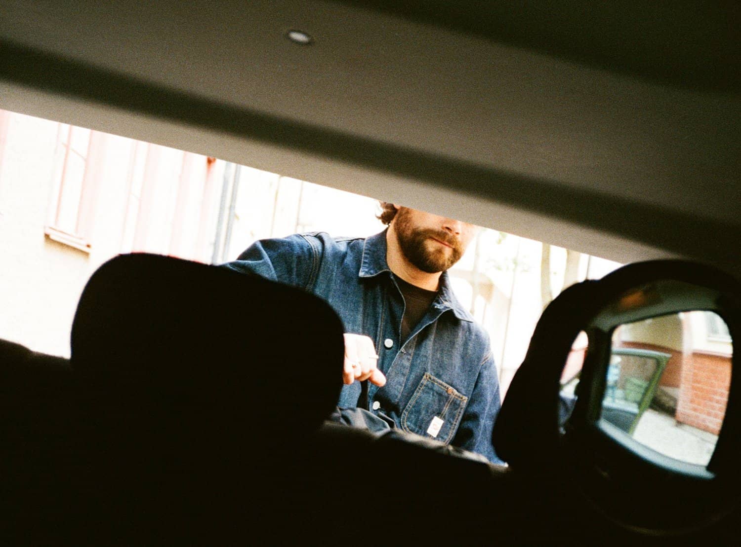 Förare packar ur väska från bakluckan på bil